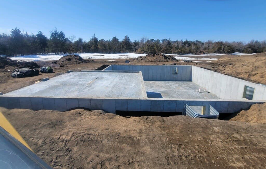 A poured basement foundation and garage slab waiting for the framers
