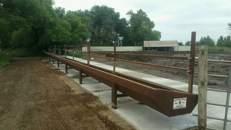 A long concrete feed bunk run set on a fresh pad