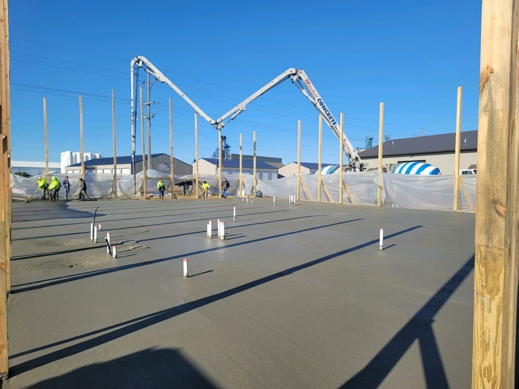 Boom pumps placing a large commercial floor on pour day