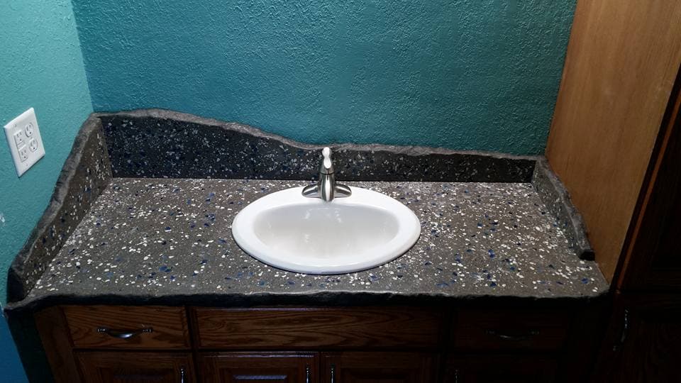 A cast concrete countertop with an integrated sink and rock-face edge