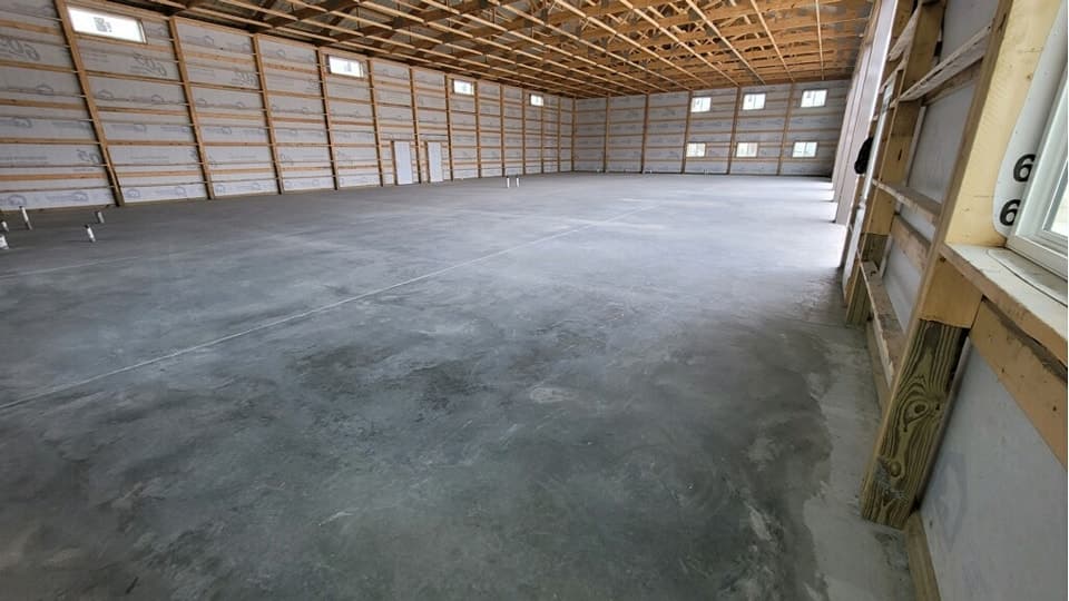 A finished concrete floor through a framed warehouse interior