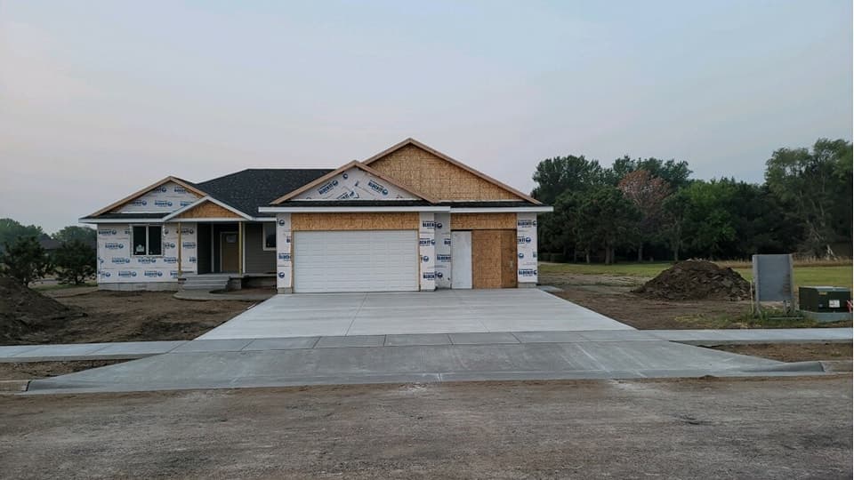 A finished concrete driveway and apron poured at a newly framed Mitchell area home