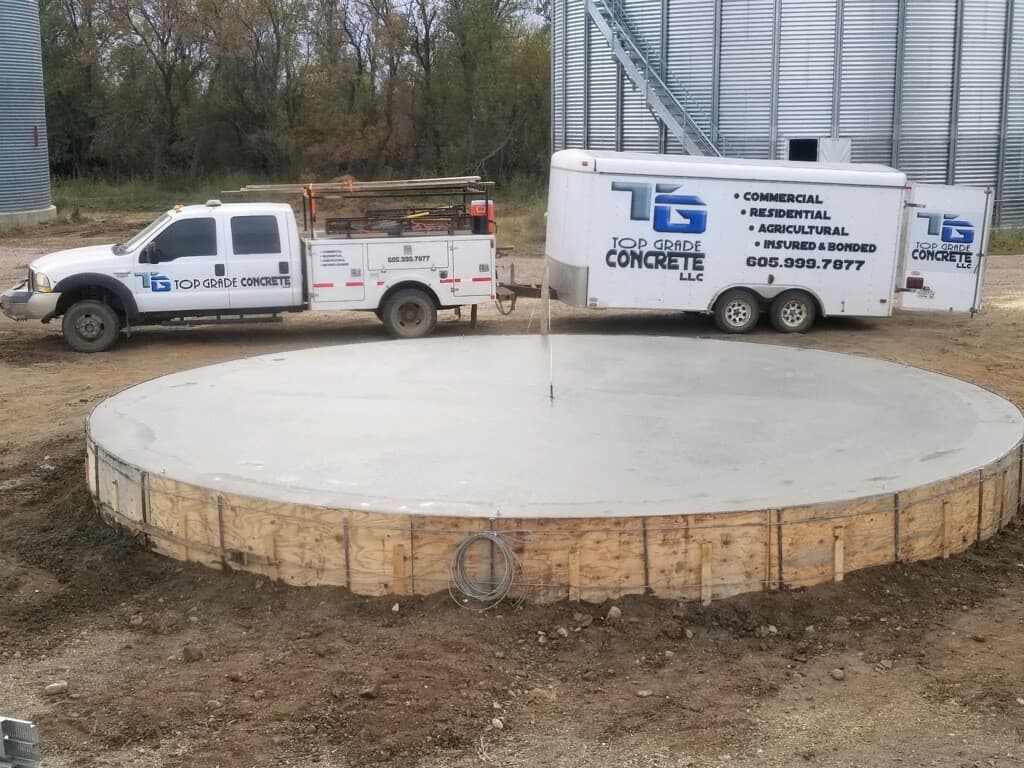 The Top Grade Concrete truck and trailer at a finished grain bin pad